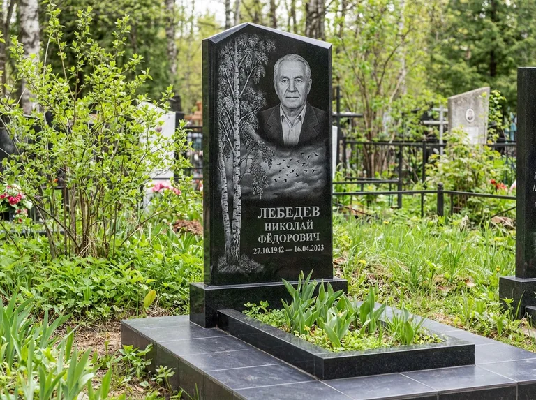 Памятник с гравировкой берёзы: вертикальная стела со скошенным верхом — берёза и стая птиц в небе, гранитный цоколь с тёмной плиткой, работа «Лебедев» в Набережных Челнах