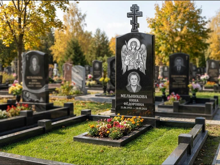 Памятник с гравировкой иконы: округлая стела-медальон с ликом — гравировка Богородицы «Семистрельная», луговые травы и полевые цветы за участком, работа «Гущин» в Набережных Челнах