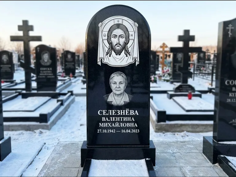 Памятник с гравировкой иконы: небольшая скромная одиночная стела с именной иконой — золочёный нимб на образе, аккуратный участок с газоном, работа «Ковалёв» в Набережных Челнах