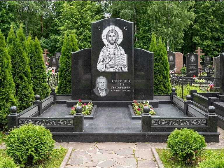 Памятник с гравировкой иконы: широкая горизонтальная лежачая плита-стела — икона в резной рамке-киоте, серая гравийная отсыпка с бордюром, работа «Богданова» в Набережных Челнах