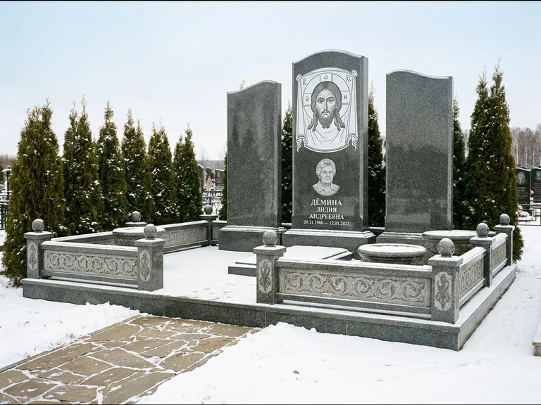 Памятник с гравировкой иконы: узкая вертикальная стела-пилон с ликом — икона в резной рамке-киоте, открытая лужайка без ограды, работа «Одинцов» в Набережных Челнах