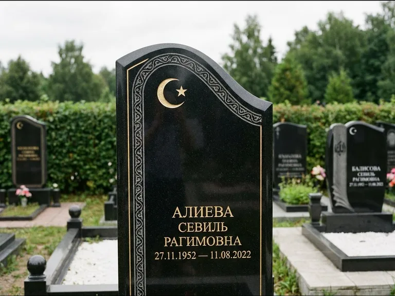 Мусульманский памятник: асимметричная скошенная стела — белая гравировка силуэта мечети с минаретами, живая изгородь из кустарника, работа «Алиева» в Набережных Челнах