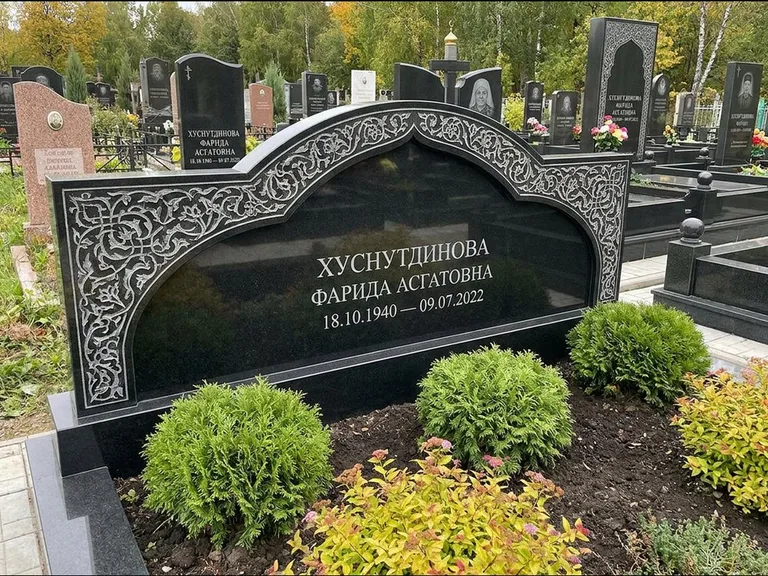 Мусульманский памятник: вытянутая горизонтальная семейная стела с аркой — белая гравировка силуэта мечети с минаретами, участок с декоративными кустами, работа «Зарипова» в Набережных Челнах