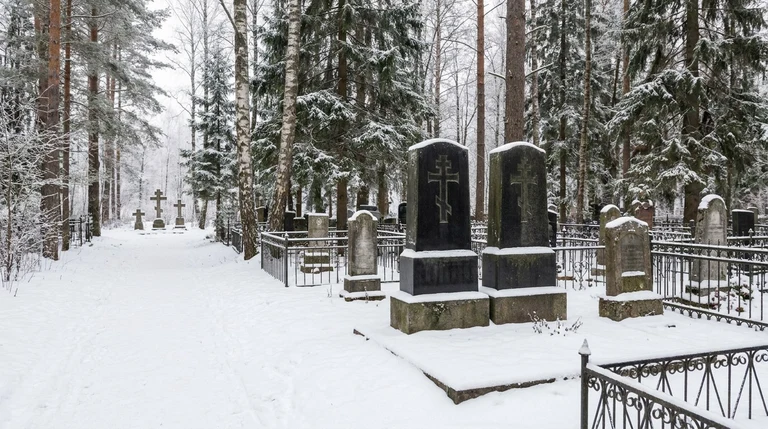 Гранитный памятник на Заозёрском кладбище в Перми среди соснового леса