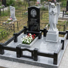 Памятник из чёрного гранита со скульптурой скорбящего ангела из белого мрамора